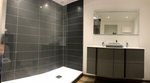 Een douche, een haardroger, handdoeken, toiletpapier