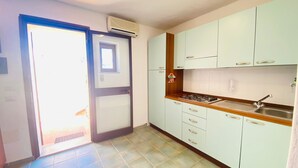 Una cocina con armarios blancos, una estufa a gas y un lavamanos.
