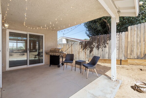 Enjoy al fresco dining and socializing in this outdoor space with a barbecue grill and seating for two.