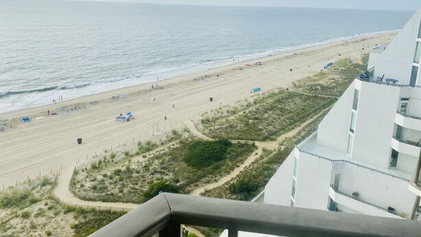 A beach view from a balcony with a clear sky. - The Plaza - Direct Oceanfront  Luxury Condo with Beach bar-Discount weekly  (Ocean City)
