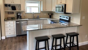 A kitchen with white cabinets, a granite countertop, a built-in oven, and a coffee station. - Lakefront Cabin : Boat Slip : Dock : Kayaks : Families : Internet (Jacksboro)