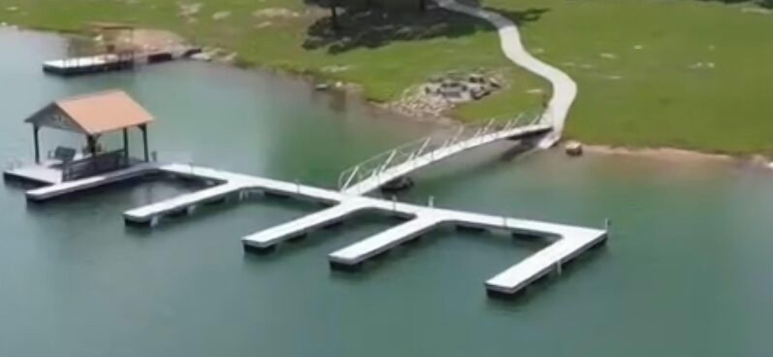 Een steiger die uitsteekt in het water, met een klein gebouw aan het einde.