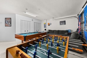 A room with a foosball table, a pool table, and a sofa. - 463 -4 bedroom villa with south facing private pool & Spa (Kissimmee)