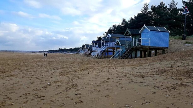 Ein Strand mit Holzstrandkörben und einem Sandstrand.