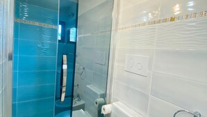 Ein modernes Badezimmer mit einer gläsernen Duschkabine, einer weißen Toilette und einem Waschbecken.