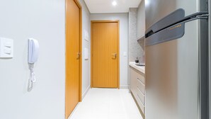 A modern kitchen with a stainless steel refrigerator, wooden cabinets, and a white tiled floor. - Apto Completo no Eco Resort (Rio Formoso)