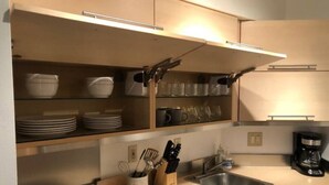 A modern kitchen with built-in shelves, a sink, and a coffee maker.