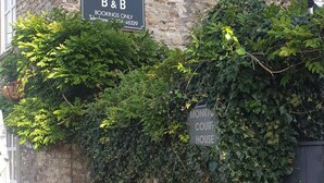 Un edificio de piedra con un letrero que dice 'Monkton Court House B&B' y un número de teléfono.