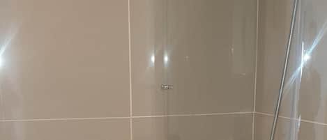 Une salle de bain moderne avec une baignoire sur pieds, une douchette et une cabine de douche en verre.