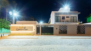 Um edifício moderno com uma placa que diz "QUINTA DO MAR" e uma área de entrada pavimentada.