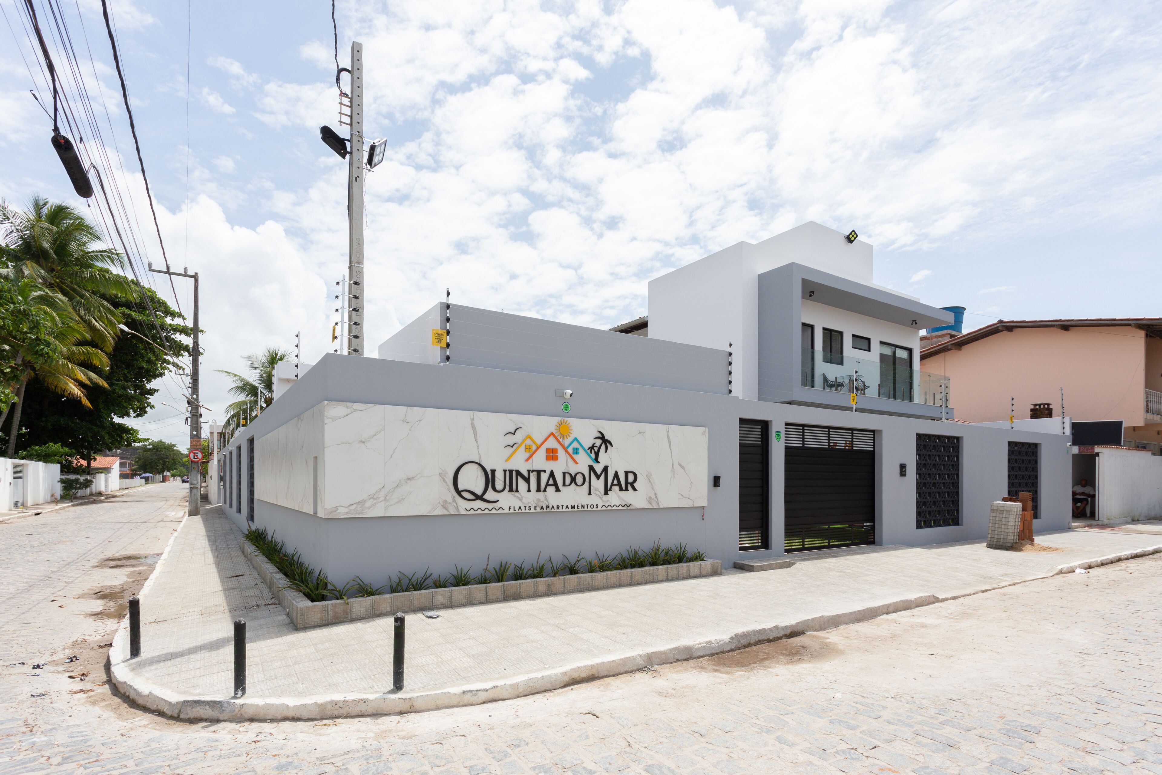 Un edificio moderno con un letrero que dice "Quinta do Mar" y una entrada protegida por una reja.