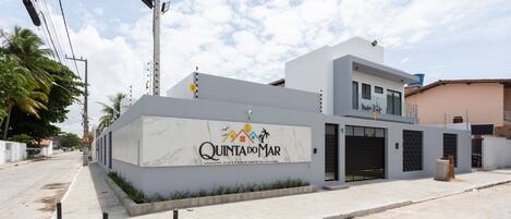 Un edificio moderno con un letrero que dice "Quinta do Mar" y una entrada protegida por una reja.