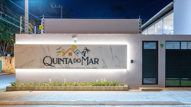 Um edifício com uma placa que diz "Quinta do Mar" e "Apartamentos Flat".