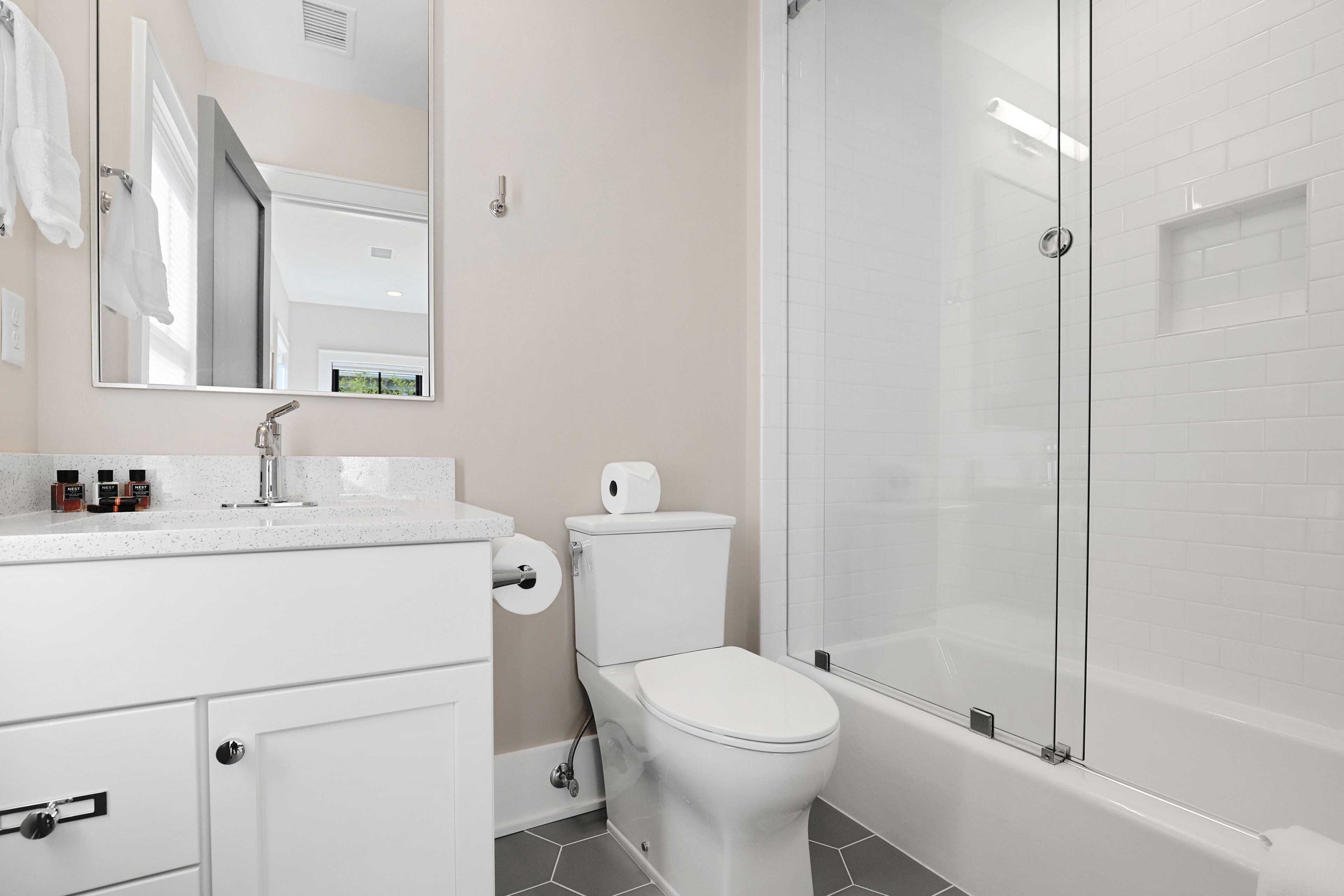 A modern bathroom with a toilet, sink, and shower area.