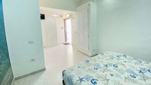 Un dormitorio con cama, armario y puerta que da a otra habitación.