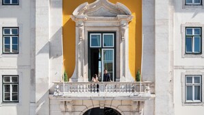 Un bâtiment doté d’un balcon, d’un mur jaune et présentant un style architectural classique.