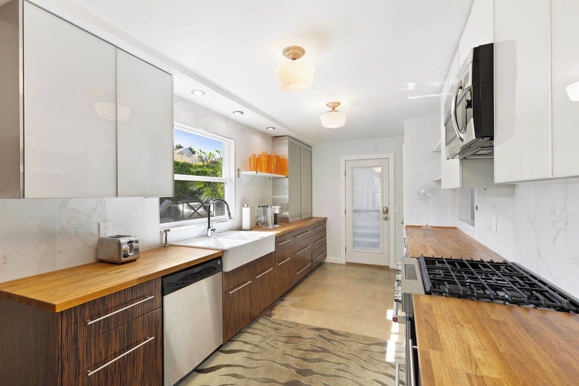 A modern kitchen with wooden countertops, a built-in dishwasher, and a gas stove.