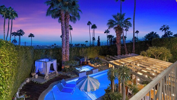 Un espace piscine doté d’un jacuzzi, de chaises longues et de parasols.