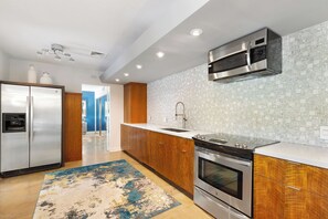 A modern kitchen with stainless steel appliances, a wooden cabinet, and a tiled backsplash. - Joplin House - Poolside Paradise w/ Amazing Views! (Palm Springs)