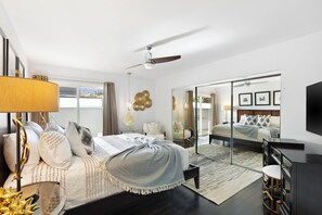 A modern bedroom with a large bed, a ceiling fan, a TV, and a sliding glass door leading to a balcony. - Joplin House - Poolside Paradise w/ Amazing Views! (Palm Springs)