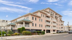 A multi-story hotel with balconies, a covered entrance, and a parking area. - 4br Beachfront Condo with Ocean Views and Pool (Wildwood Crest)