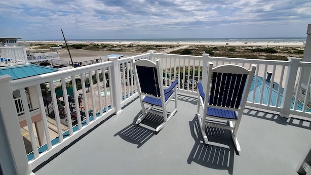 Un balcone con due sdraio e vista sulla spiaggia.
