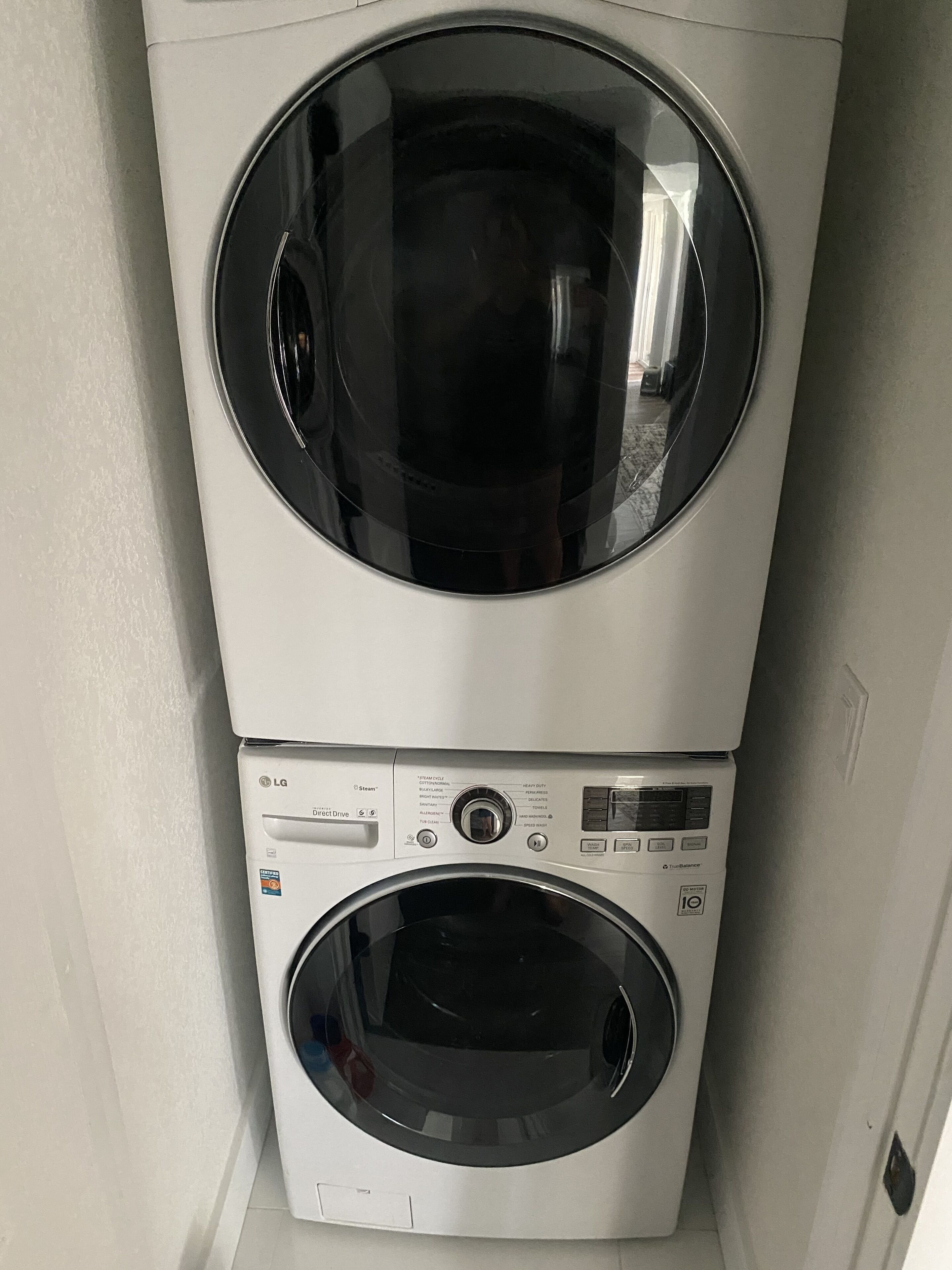 A stacked washer and dryer unit with control panels and a transparent door.