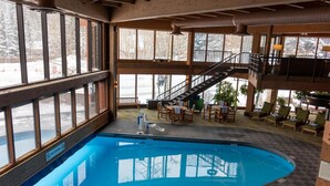 Ein Poolbereich mit einem 'No Diving'-Schild, Holzdeck-Sitzgelegenheiten und einer Treppe zu einer erhöhten Ebene.