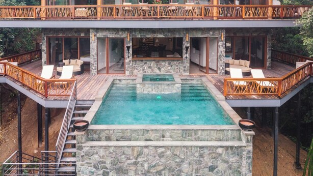 A luxurious pool area with a stone deck, wooden deck, and a glass balustrade. - Valley Stream Private Eden (St. Margaret's Village)