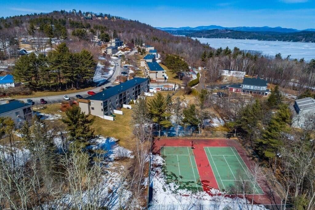 A residential area with houses, a tennis court, and a parking lot.
