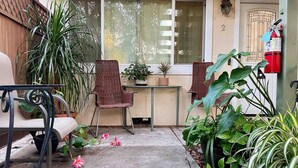 A small patio area with a table and chairs, surrounded by potted plants and a fire extinguisher. - 💎Cozy 1B/1B in a prime location • 🌲AC/ 1000mb wifi/ Washer, dryer/ more… (Sunnyvale)