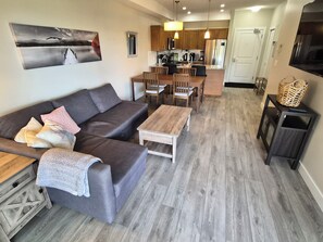 A modern living room with a sofa, coffee table, and dining area.