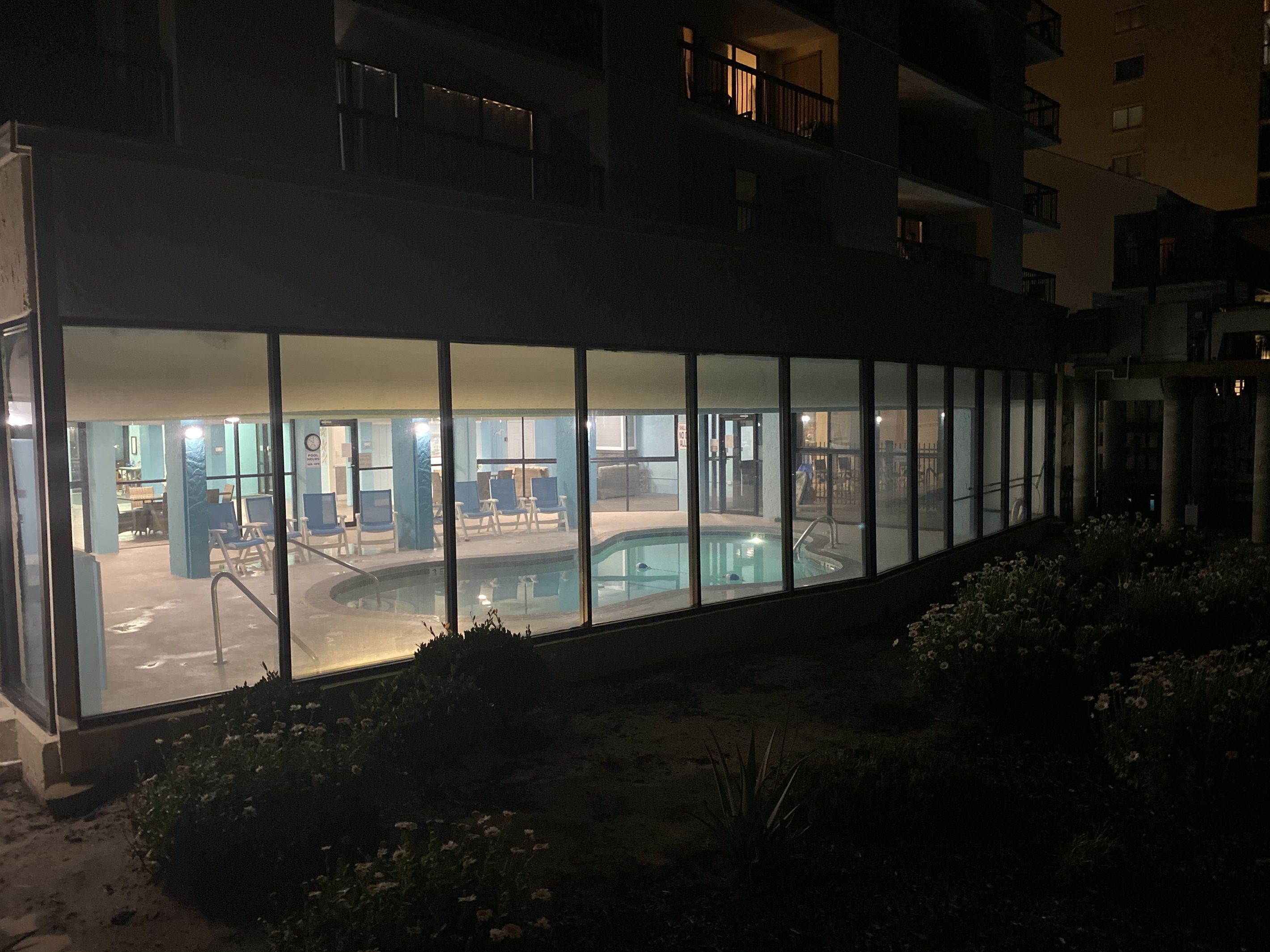 A building with a pool area visible through large windows.