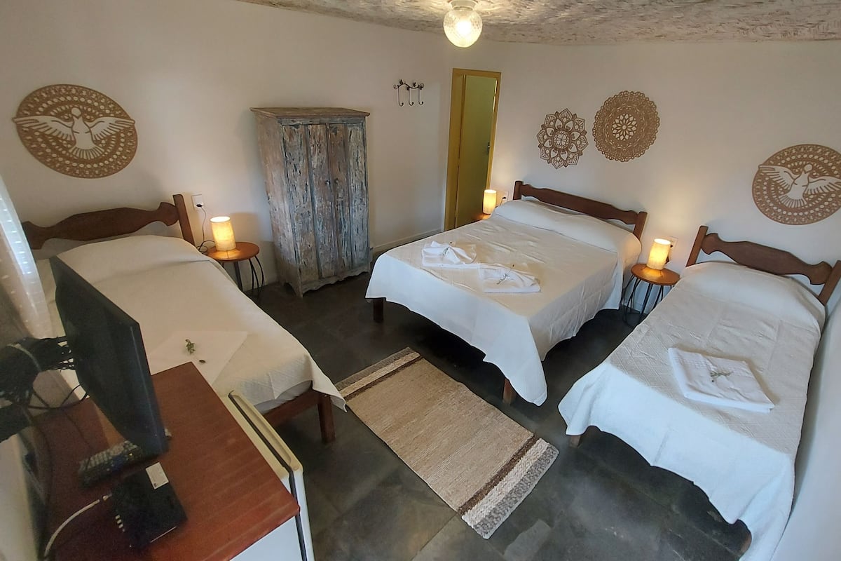 Una habitación con dos camas, un aparador de madera y decoración en la pared.