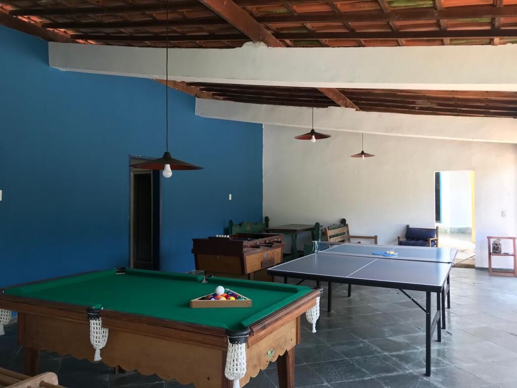 A room with a pool table, a ping pong table, and a billiards table.