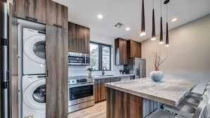 A modern kitchen with built-in appliances, a marble countertop, and wooden cabinetry. - LaFave-Luxury Villa at Zion: Orderville Canyon (Springdale)