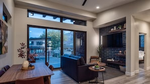 Een modern interieur met een eethoek, een bank en een open haard.