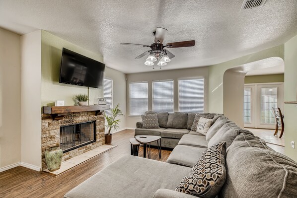 Cozy living room with a fireplace, sectional sofa, and flat-screen TV.
