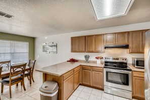 Enjoy cooking in the well-equipped kitchen with a central island, stovetop, oven, and microwave.