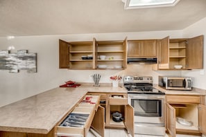 Enjoy cooking in this kitchen with a stove, microwave, and oven, plus ample storage and a large window with a view.