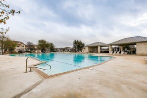 Relax by the pool surrounded by lounge chairs and umbrellas.