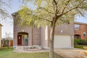 Stunning brick facade with a charming arched entrance and beautifully manicured front yard.
