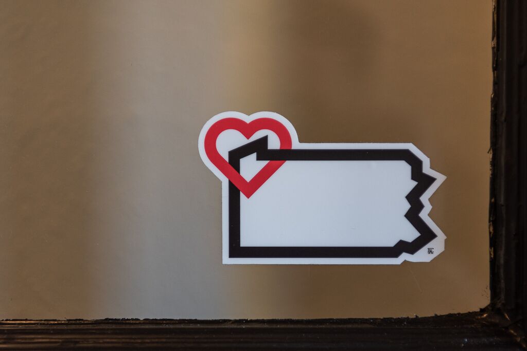 A sticker with a heart and a tag on a door.
