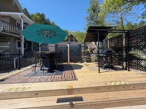 A backyard with a patio area, a barbecue grill, and a covered seating area.