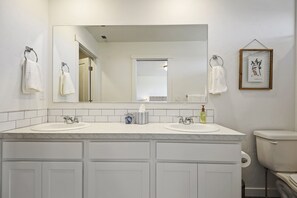 Een bad/douchecombinatie, een haardroger, handdoeken, zeep