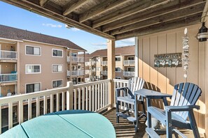 A balcony with a table and chairs, a surfboard, and a 'Welcome' sign. - "Cast-a-waves" Make every day a Holiday! (Carolina Beach)