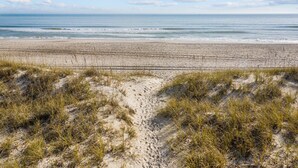 Une plage avec des dunes de sable et une vue dégagée sur l’océan.