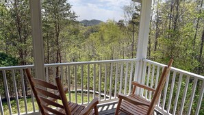 A wooden rocking chair on a porch with a view of a forested mountain. - Spacious Family Mountain Gem Nestled in Nature-5 min to Historic Murphy!  (Murphy)