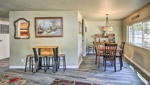 A dining area with a wooden table and chairs, a painting on the wall, and a window with a view. - Kingston Sleeper: Unique Stay Near Silver Mountain (Kingston)