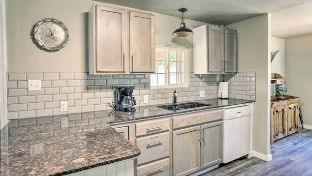 A kitchen with light wood cabinets, a granite countertop, a coffee maker, and a clock on the wall. - Kingston Sleeper: Unique Stay Near Silver Mountain (Kingston)